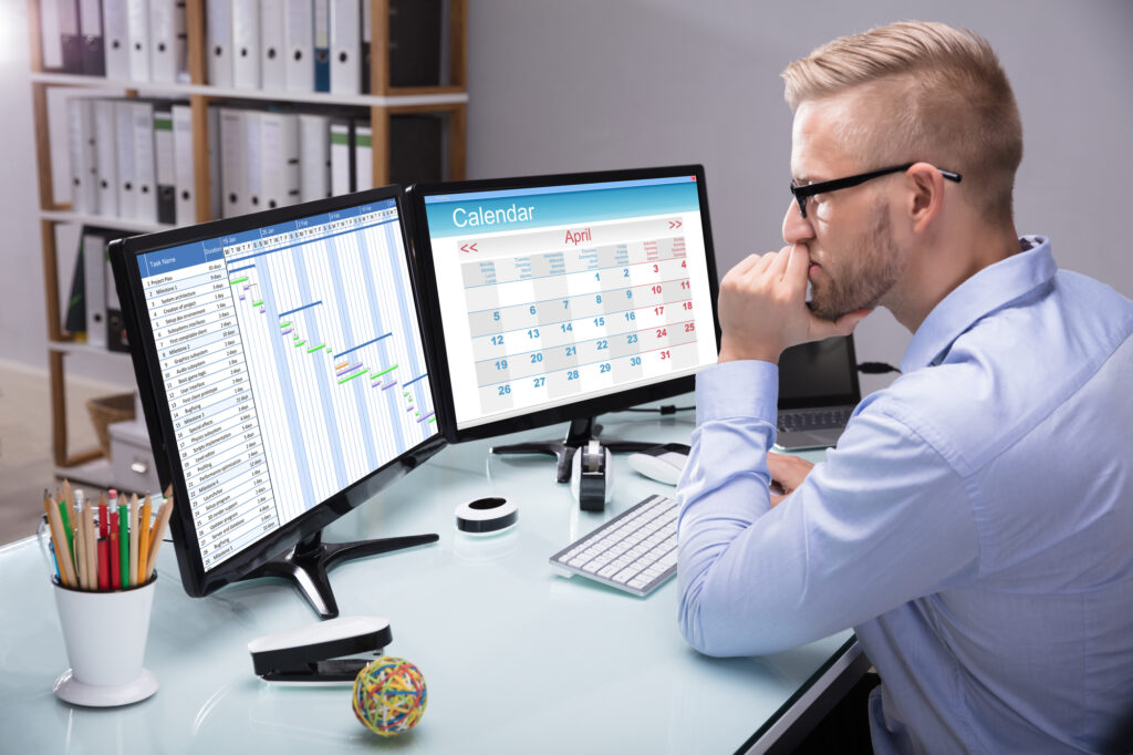 man looking at two computer screens